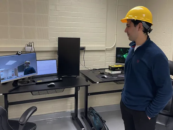 Grad researcher tests camera and program, wearing helmet