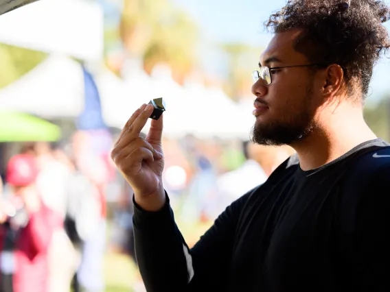 Curious student at UArizona gazing at mineral