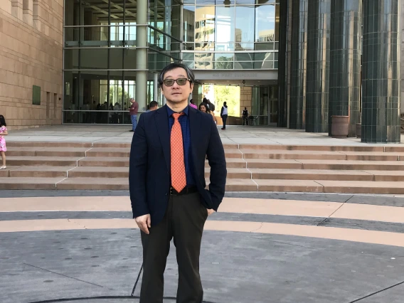 photo of Dr. Jinhong Zhang in front of a building