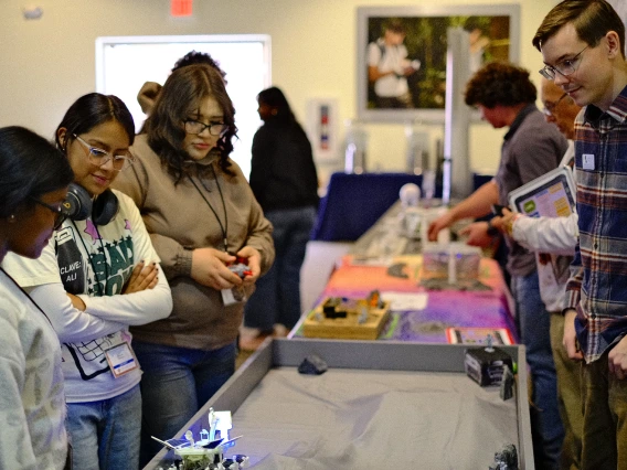 Attendants looking at different models at the Space Design Competition