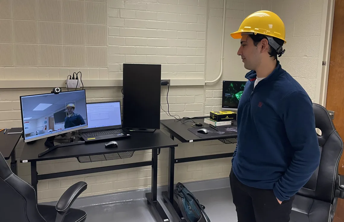 Grad researcher tests camera and program, wearing helmet