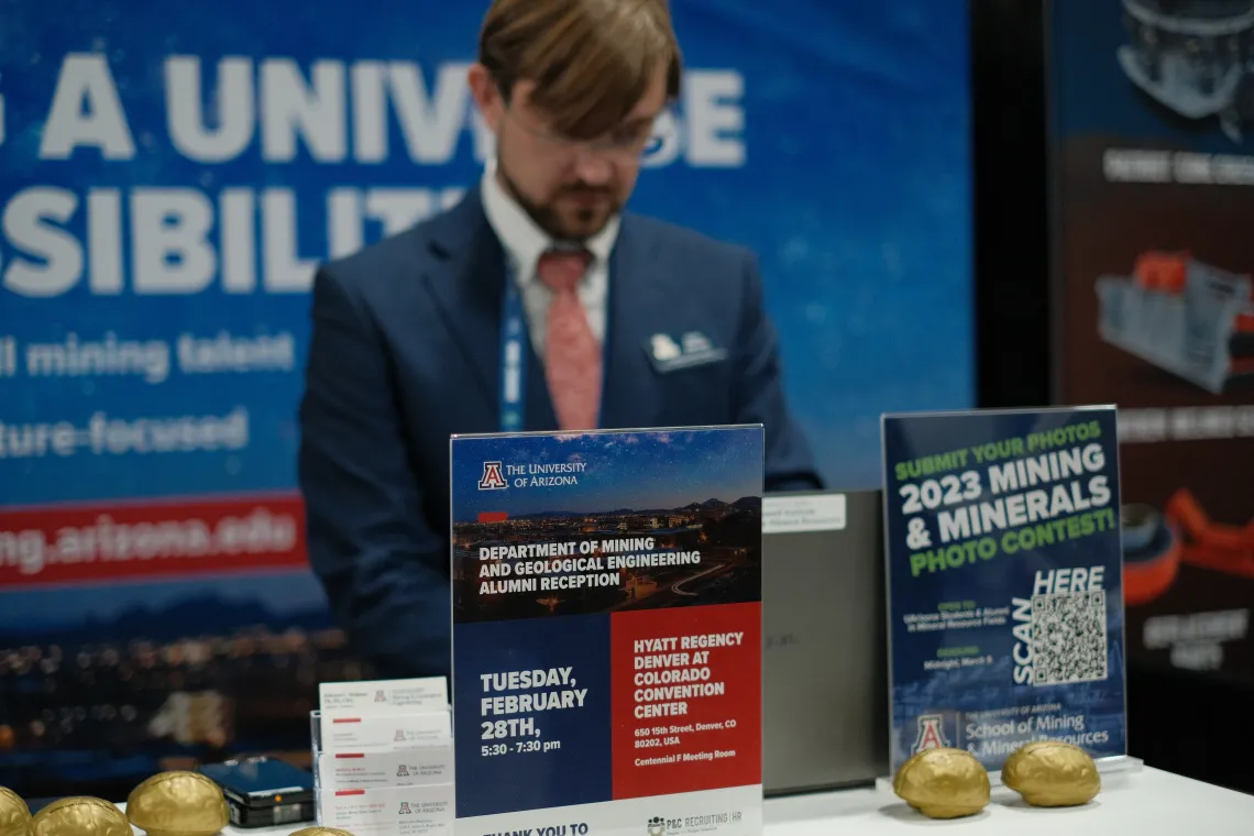 Booth signs, with Chris Earnest working in the background.