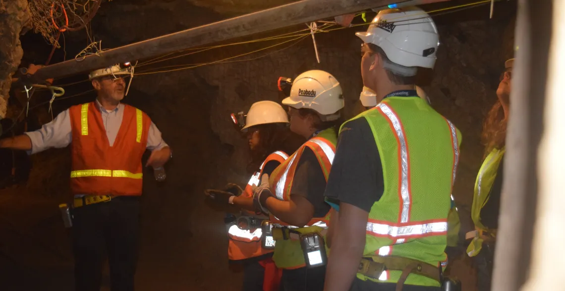 Students with mining gear inside of a mine