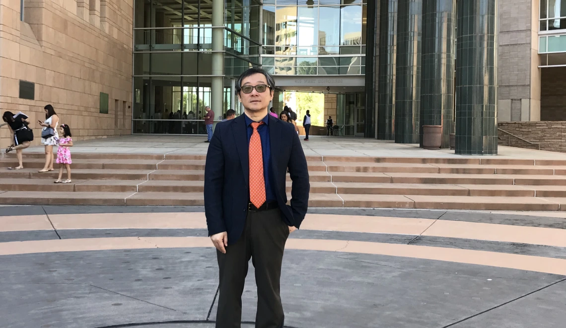 photo of Dr. Jinhong Zhang in front of a building