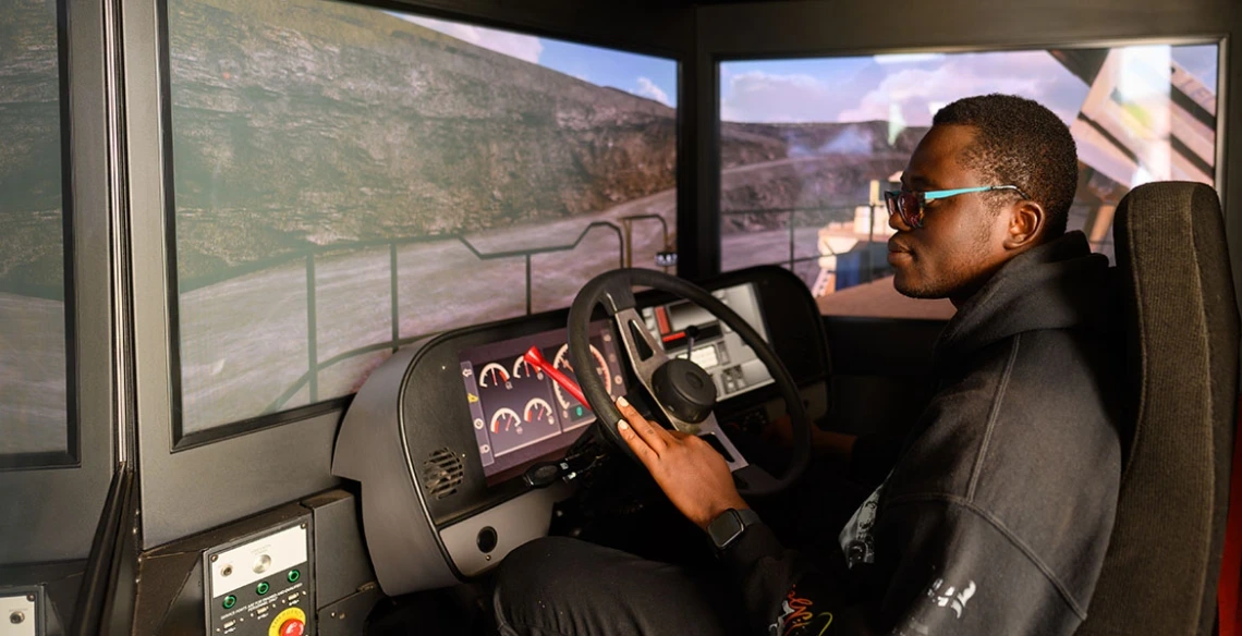 A U of A student uses Freeport-McMoRan’s haul truck simulator at a university event. 