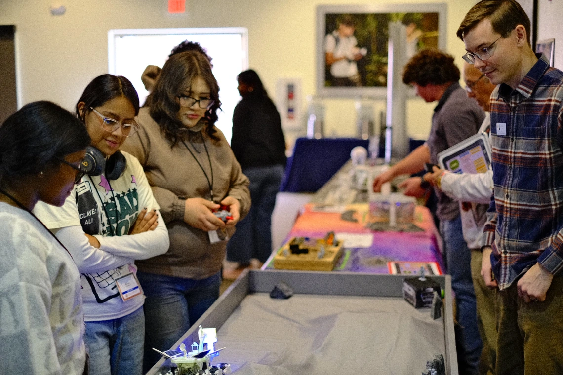 Attendants looking at different models at the Space Design Competition