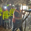 People in yellow suits inside a mine.